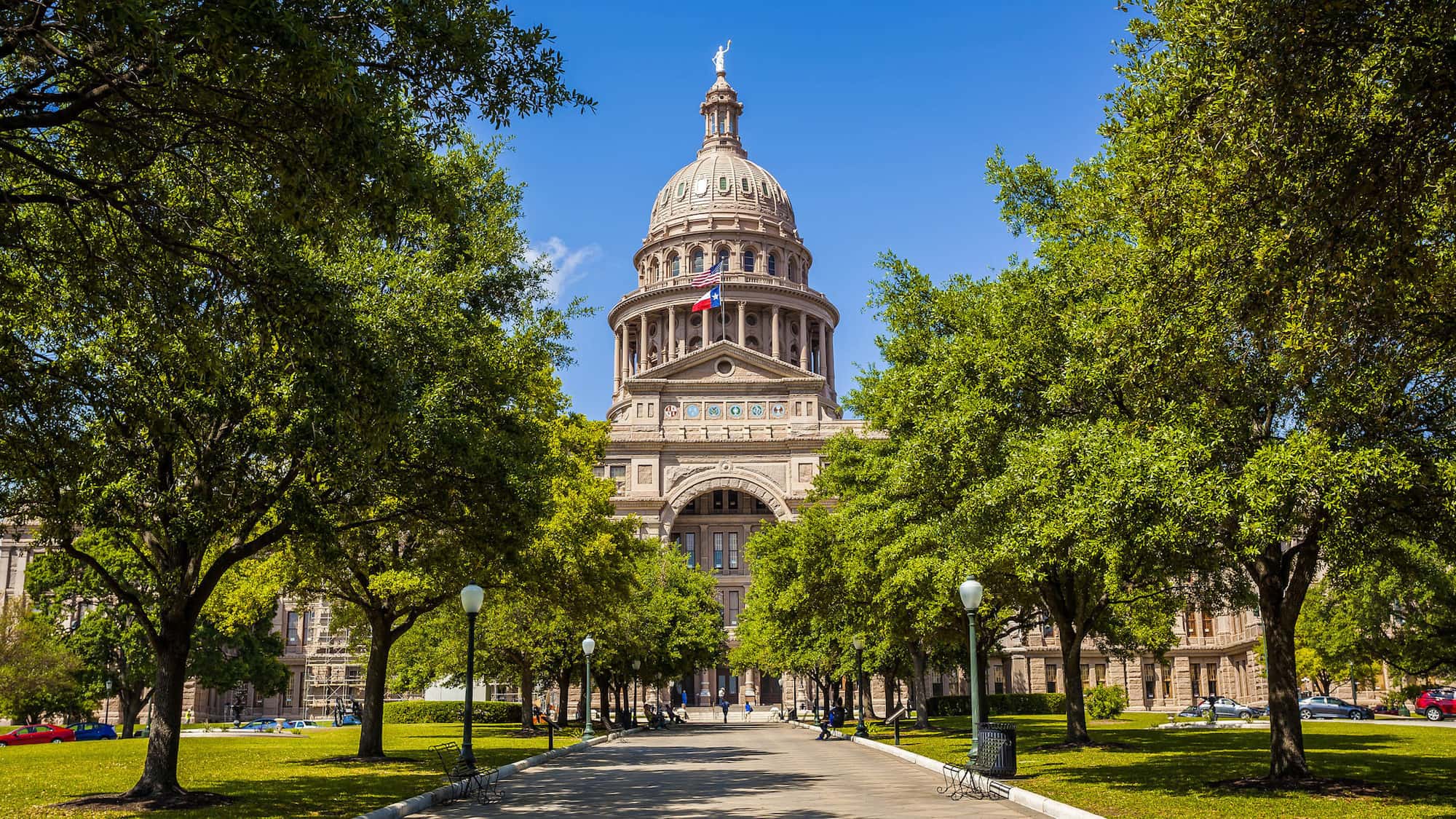 The capital building in Austin, TX, at the end of a lane lined with trees, near where Austin Landmark Property Services manages rental homes for tenants