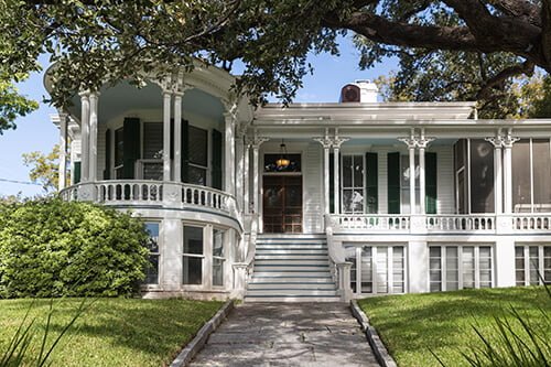 White house with an elegant front porch that may be benefiting from Austin property management